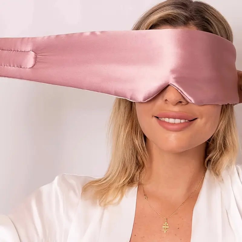Black silk sleep mask from DREAMSILK, designed to block out light and ensure restful sleep with smooth, luxurious fabric.