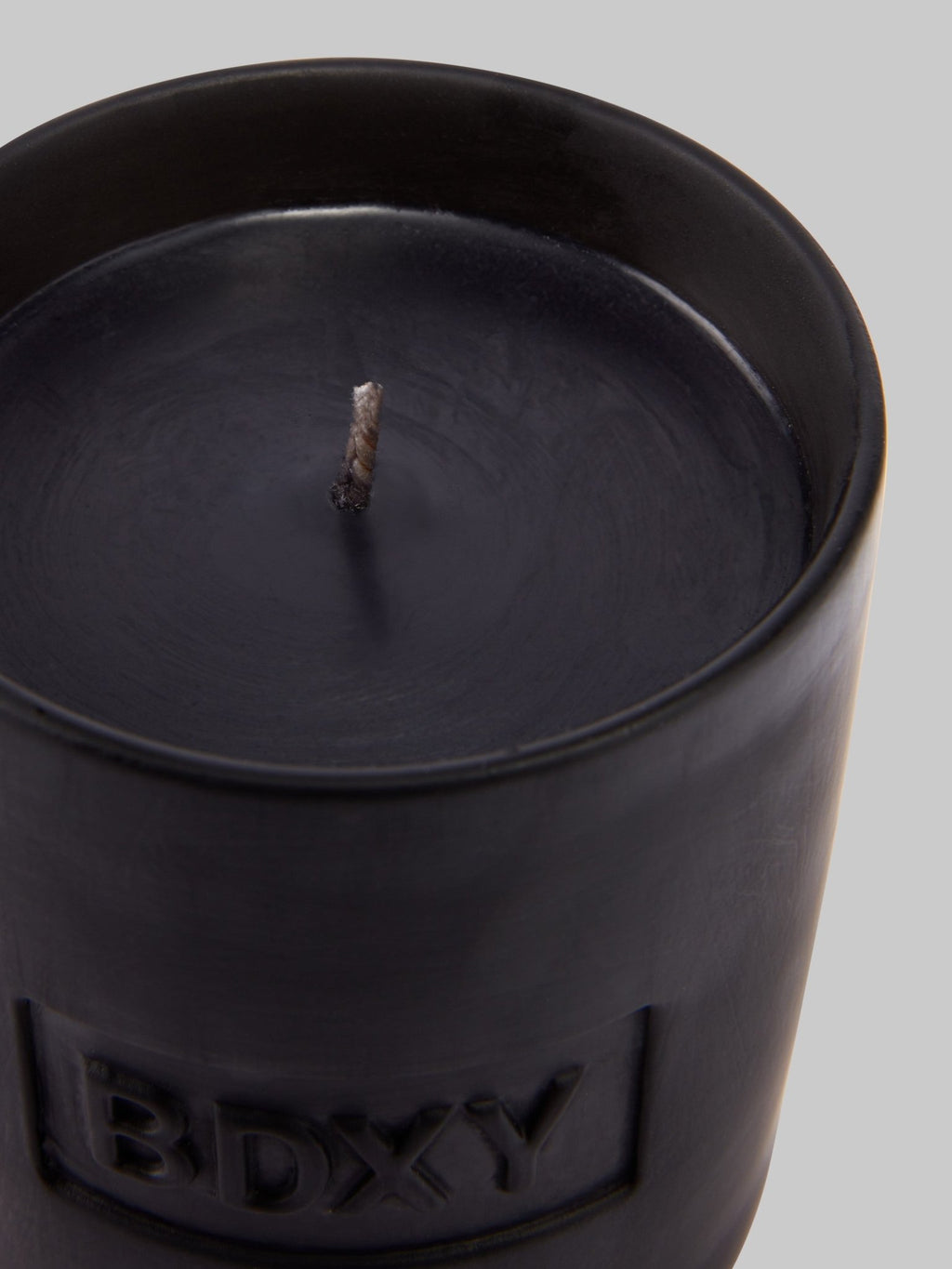 BDXY Studios Alfama scented candle with a simple glass jar and a burning wick, emitting a warm glow.