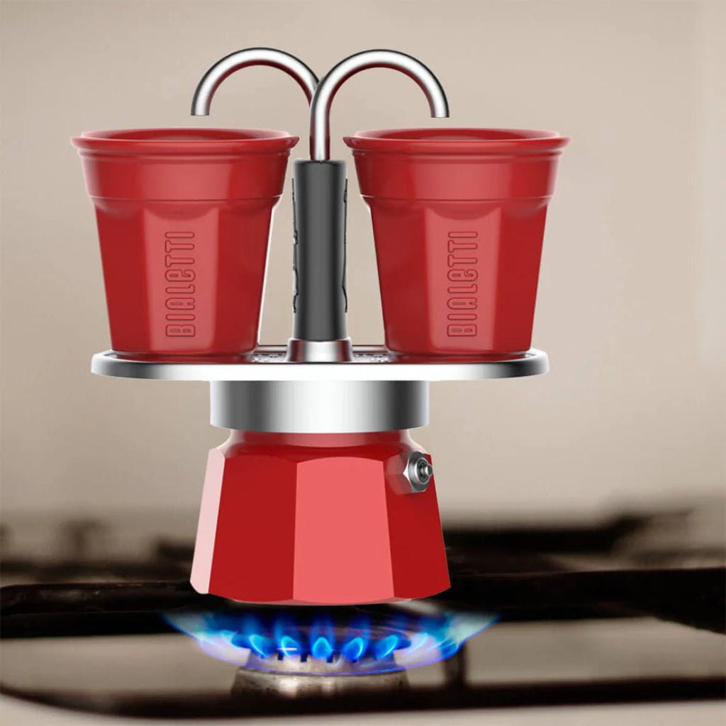 Red Bialetti Mini Express 'R' double serve coffee maker by Brew Italia, featuring two cups and a compact Italian design.
