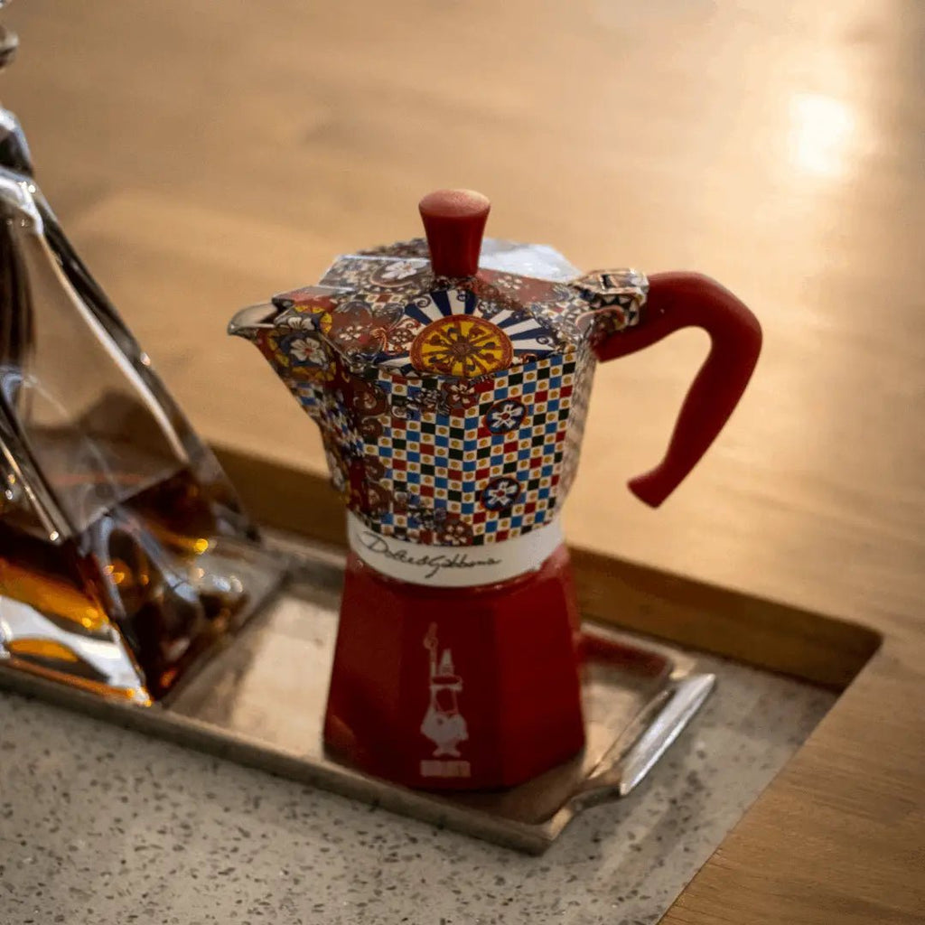 Bialetti X Dolce&Gabbana Sicilian Cart Moka Express coffee maker with colorful floral and Sicilian-inspired design, stainless steel body.