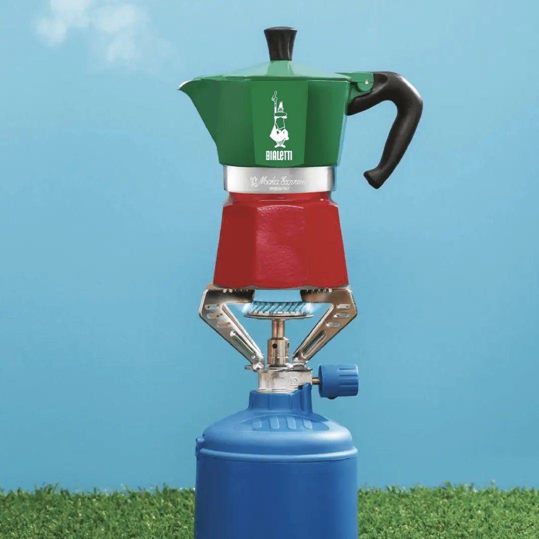 Bialetti Moka Express Tricolore Italy stovetop coffee maker on outdoor table, featuring classic aluminum design and colorful accents