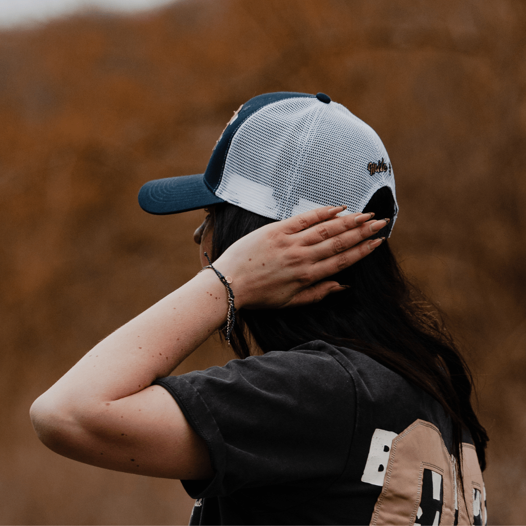 Navy trucker cap with '09' logo, made by Uggly and Co, featuring mesh back and adjustable strap, casual headwear style