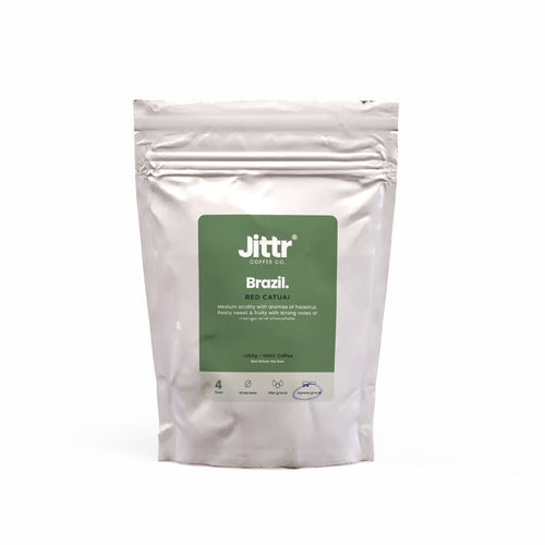 Brazil Single Origin coffee from Jittr Coffee Co, showing a bag of roasted coffee beans on a wooden surface.