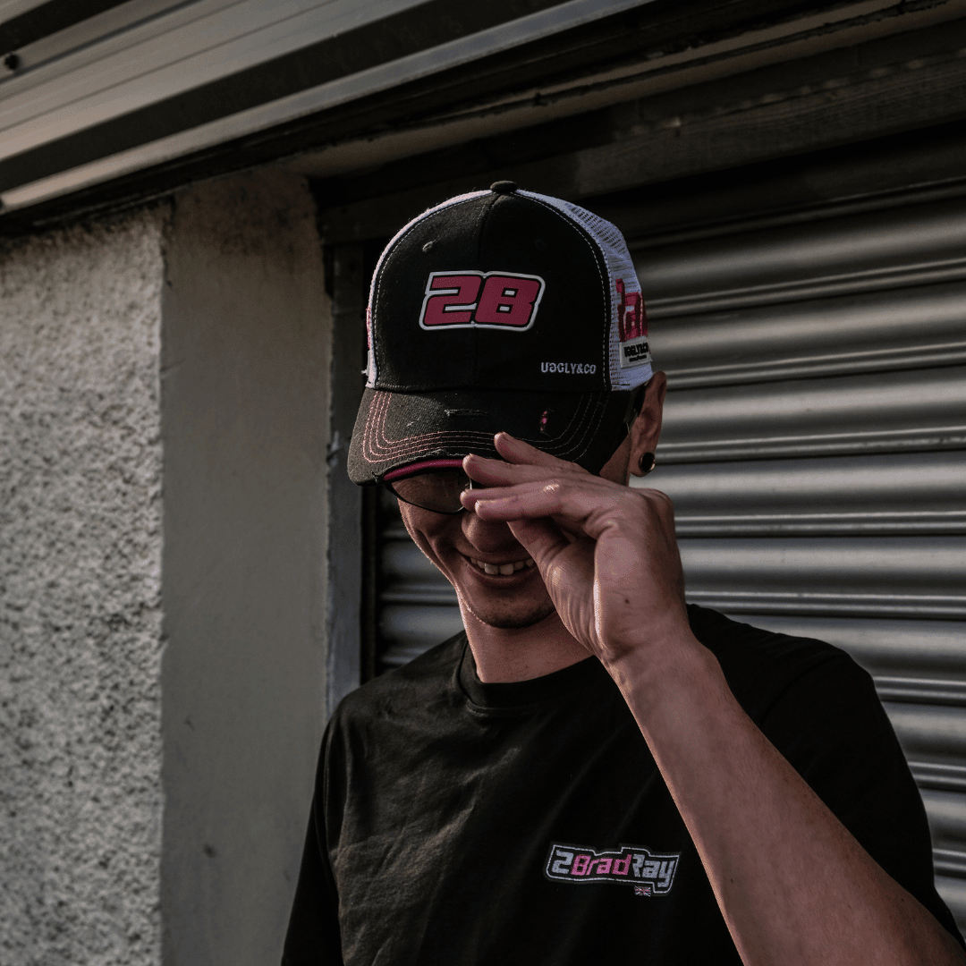 Uggly and Co Bradley Ray #28 trucker cap with logo, featuring mesh back and curved brim, on a model head.