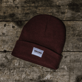 Burgundy Uggly and Co beanie hat made of soft knit material, styled for a cozy, casual look.