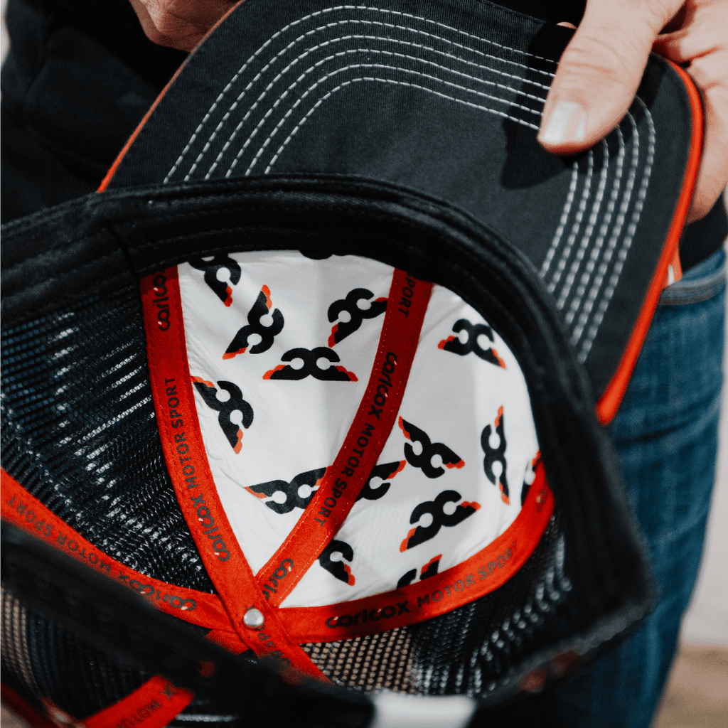 Uggly and Co Carl Cox Icon trucker hat featuring a mesh back, front logo patch, and adjustable snap closure.