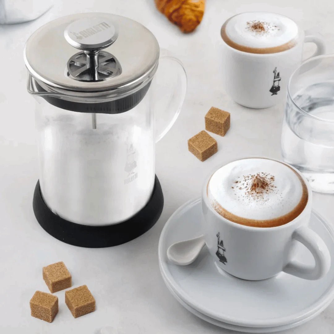 Bialetti Tuttocrema glass milk frother for coffee, Brew Italia brand, showing the clear glass frother with milk inside.