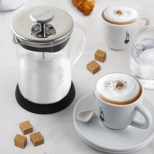 Bialetti Tuttocrema glass milk frother for coffee, Brew Italia brand, showing the clear glass frother with milk inside.