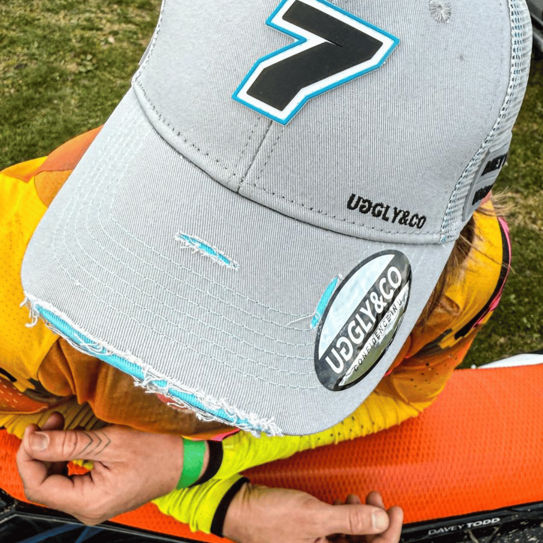 Steel grey Uggly and Co trucker cap featuring Davey Todd merchandise logo, adjustable mesh back, and structured front panel.