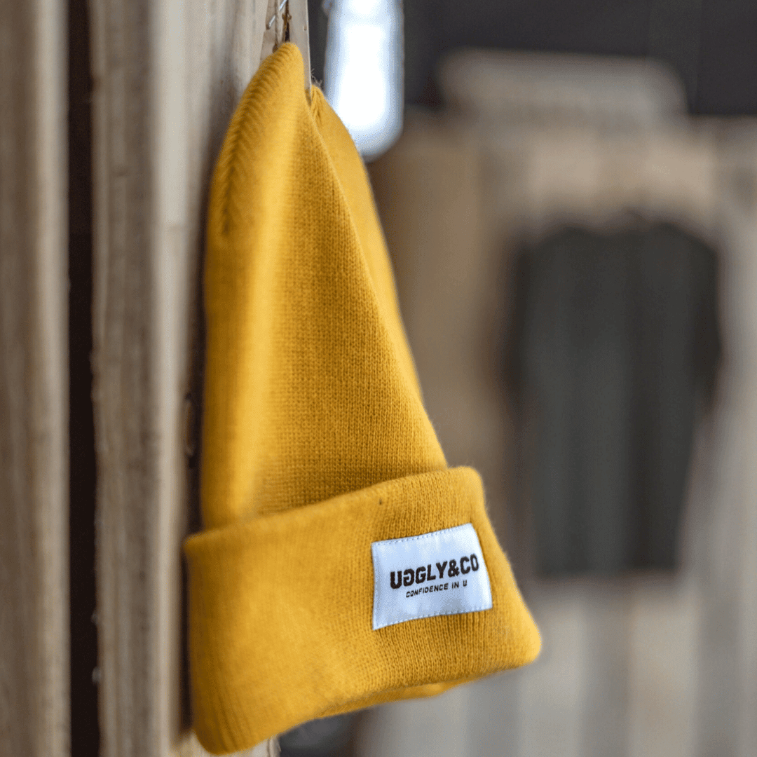 Yellow Uggly and Co beanie hat with a cozy knit texture, shown on a plain background.