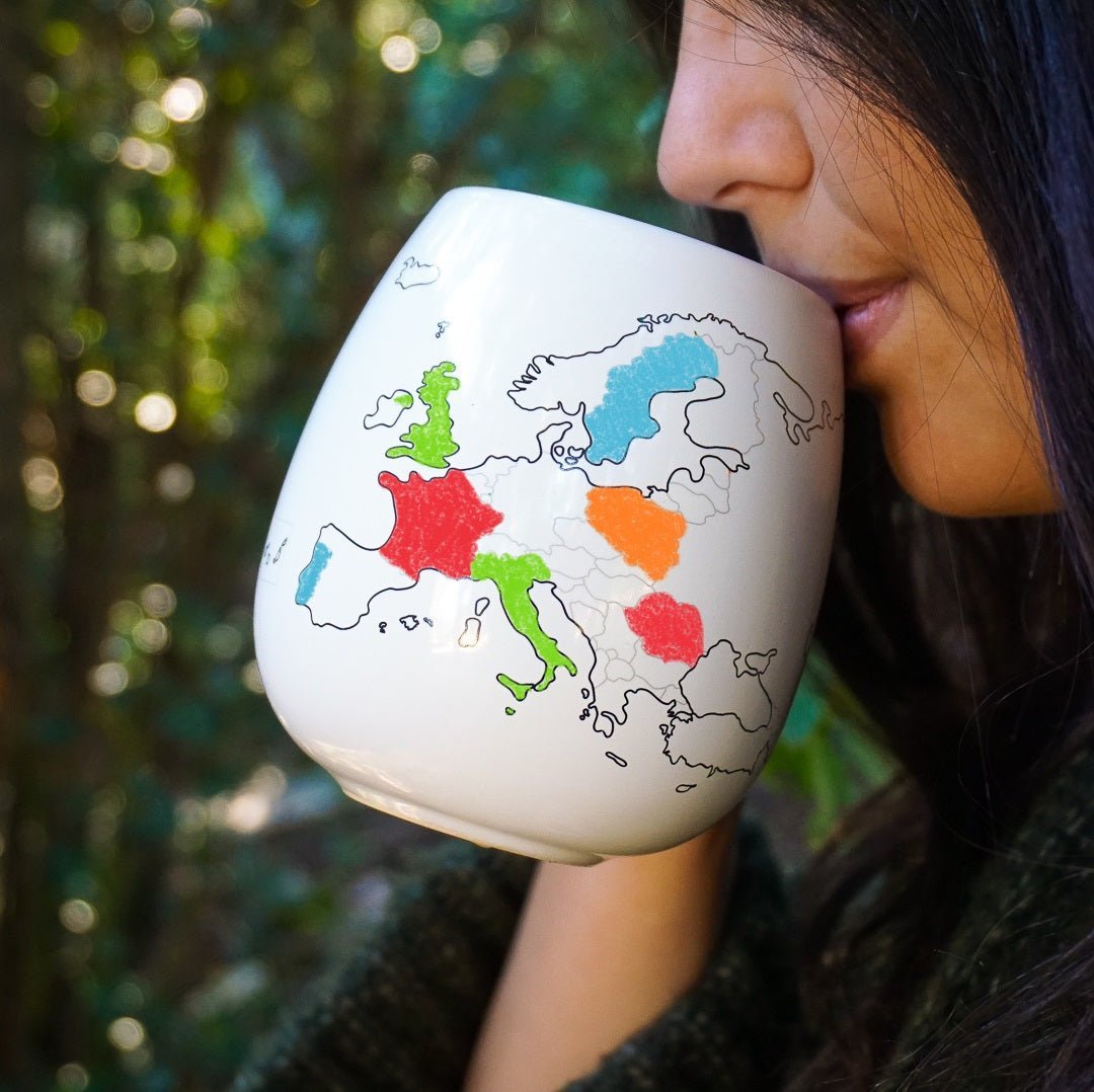 Trouvaille Europe Map Colour-In Travel Mug with a person holding and drinking from the personalized, vibrant map design.