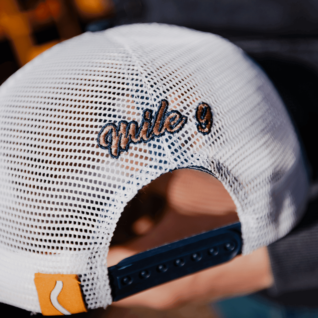 Navy '09' trucker cap by Uggly and Co with mesh back and adjustable snap closure, showcasing a vintage-style design.
