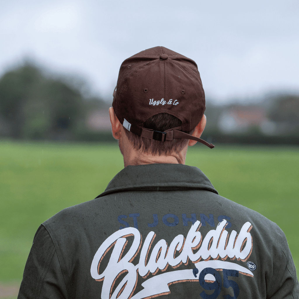 Brown Uggly and Co Aviation Diamond Trucker Hat featuring a classic baseball cap style with a bold aviation diamond logo.