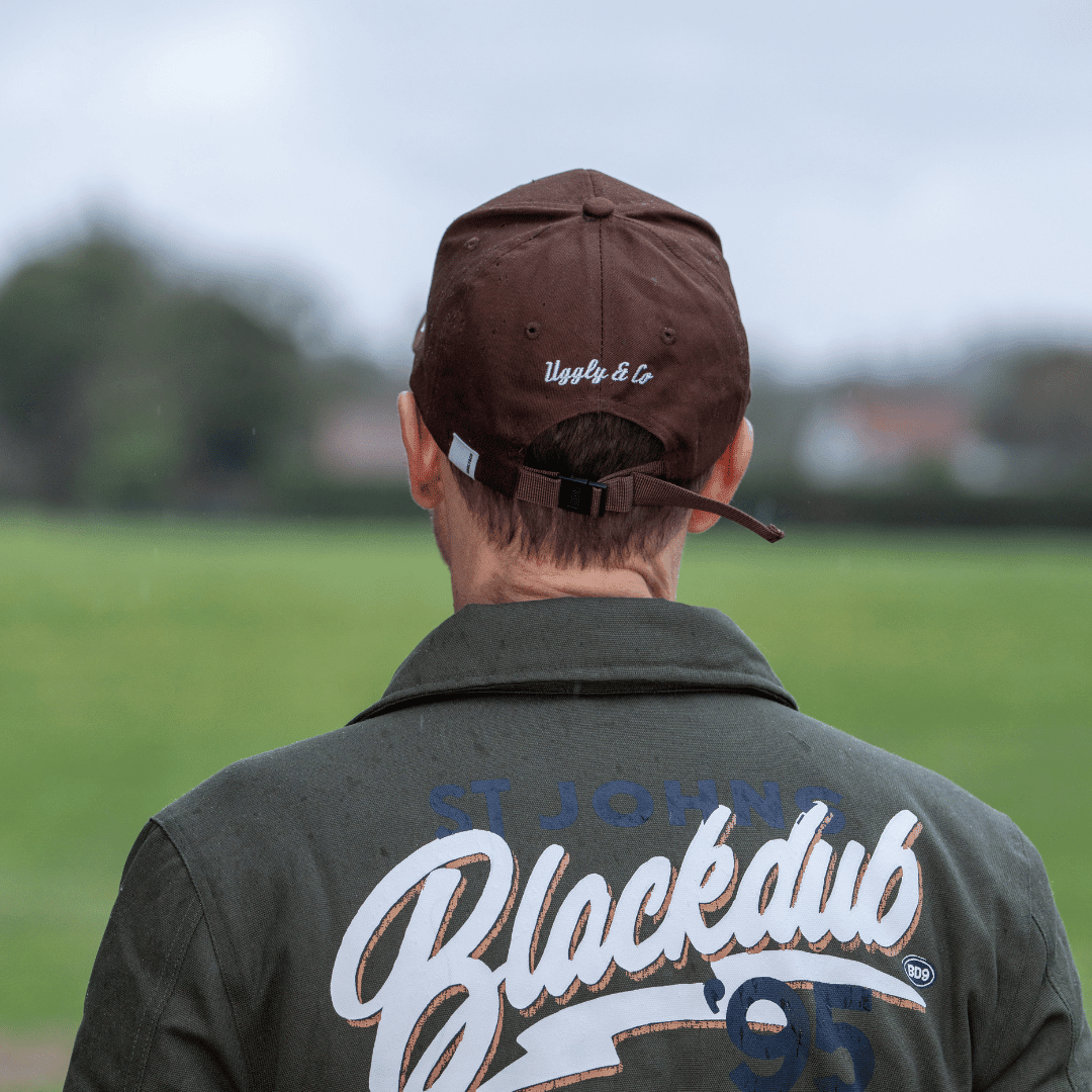 Brown Uggly and Co Aviation Diamond Trucker Hat featuring a classic baseball cap style with a bold aviation diamond logo.