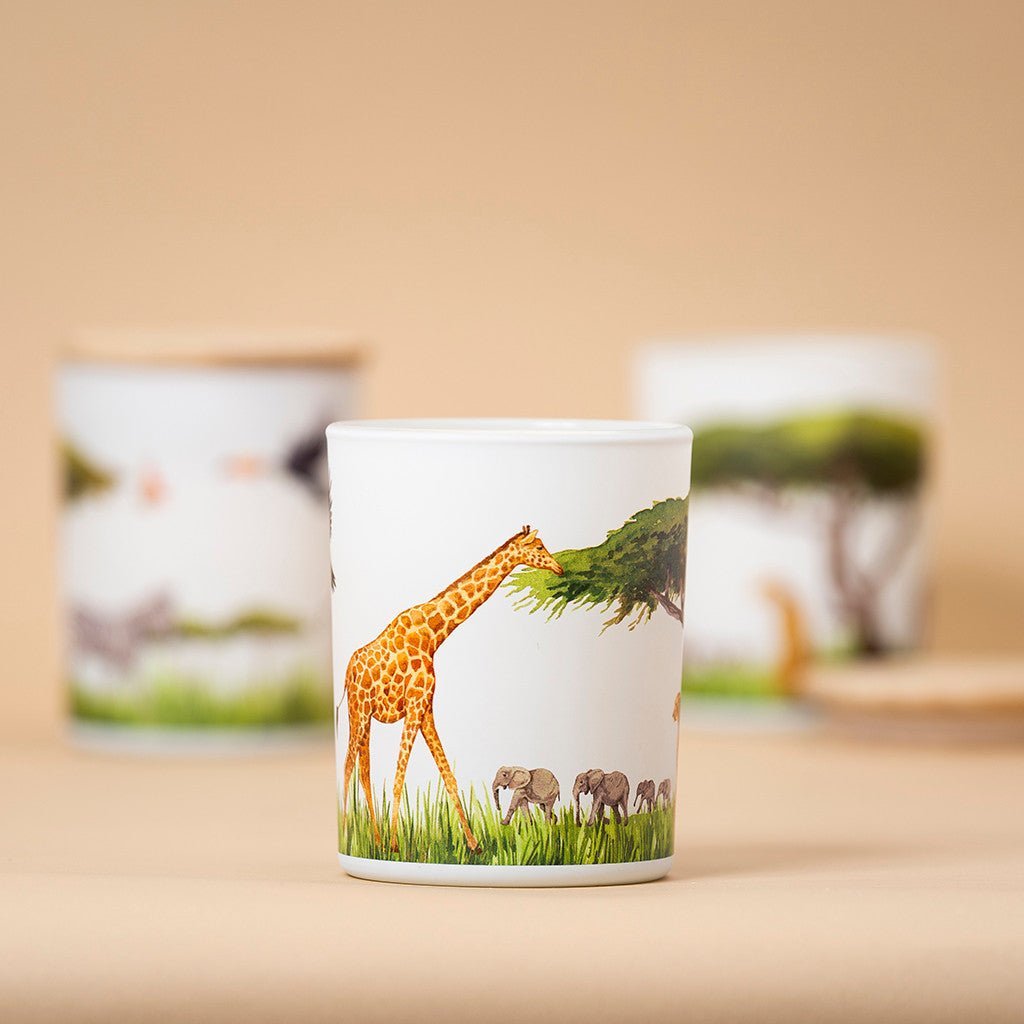 Trouvaille Grassland Soy Candle with uplifting citrus scent, featuring a 360-degree giraffe and elephants design on the candle jar.