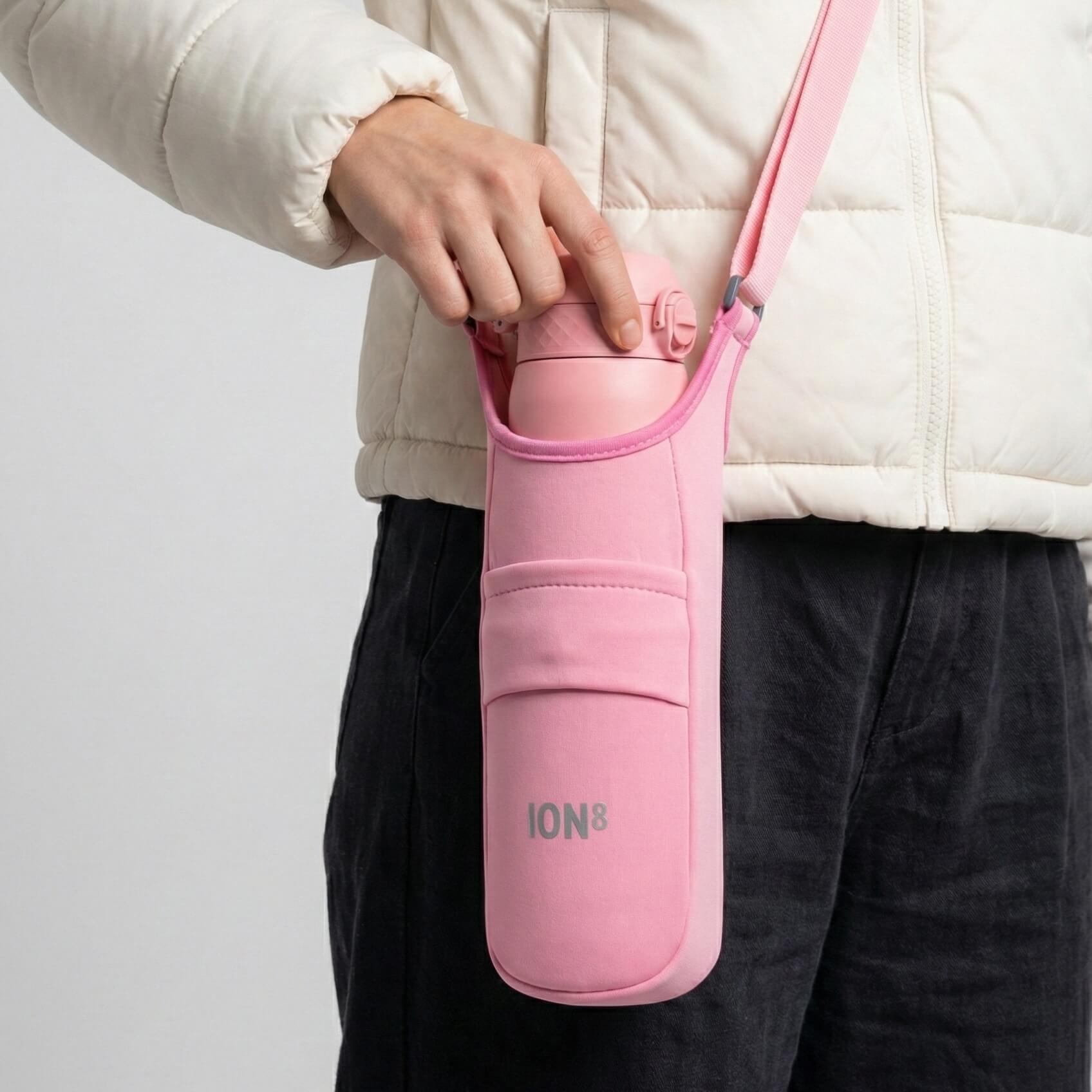 Pink lightweight sling bottle bag by ION8, versatile and compact for carrying drinks and essentials on the go.