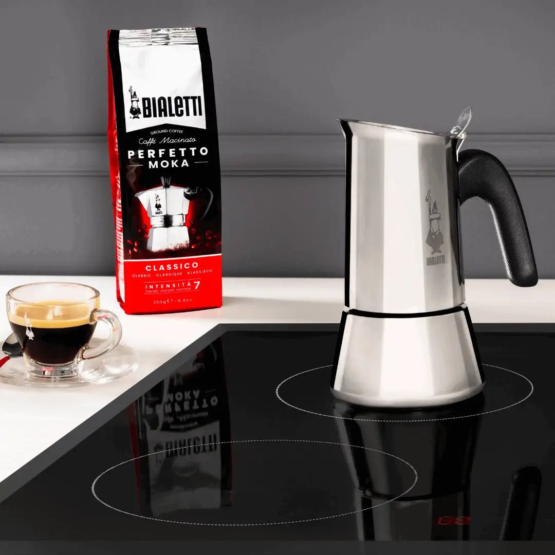 Bialetti Venus Italian coffee pot on induction stovetop, stainless steel moka pot for brewing espresso-style coffee.