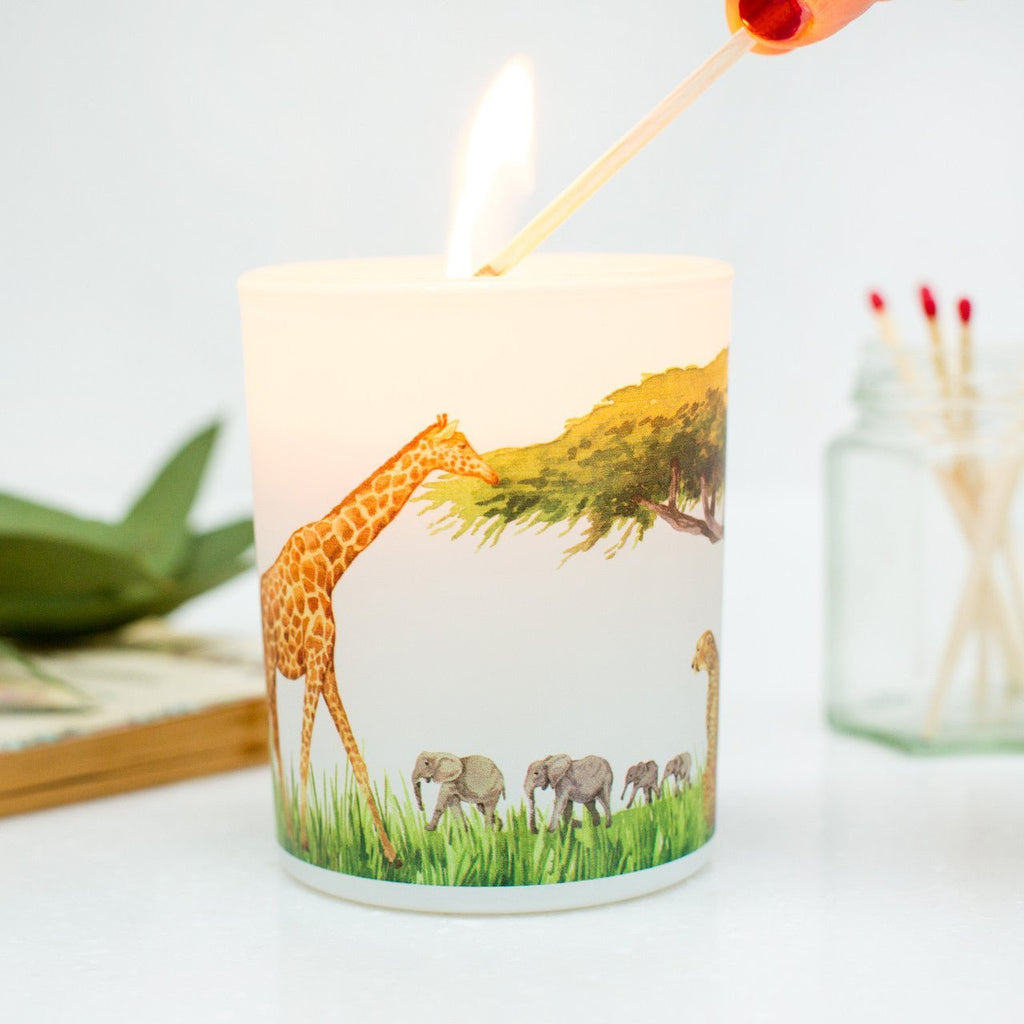 Trouvaille Grassland Soy Scented Candle with wildlife design, featuring an uplifting citrus blend and a lit wick.