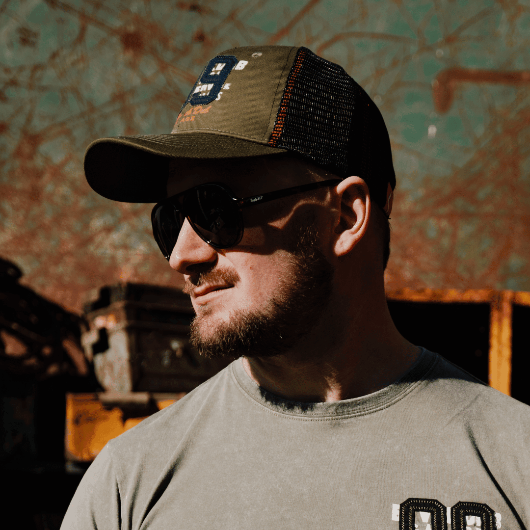 Green Uggly and Co '09' trucker hat with mesh back and curved brim, men's biker-style cap with bold embroidered design.