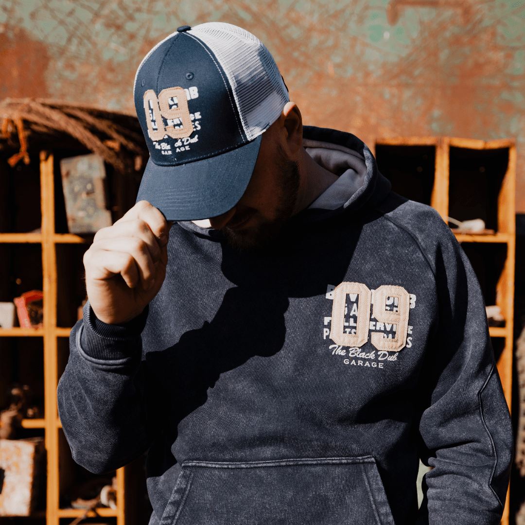 Men's navy trucker cap with '09' logo, Uggly and Co brand, featuring mesh back and adjustable snap closure.