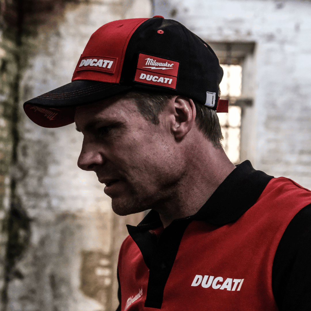 Milwaukee Tools x Ducati team-wear trucker hat, casual baseball cap with Milwaukee and Ducati logos, adjustable mesh back, black and red design.