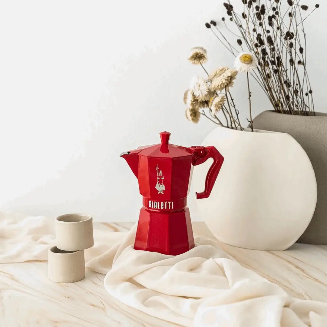 Red Bialetti Moka Express Exclusive 6-cup coffee maker by Brew Italia, with a classic stovetop moka pot design.