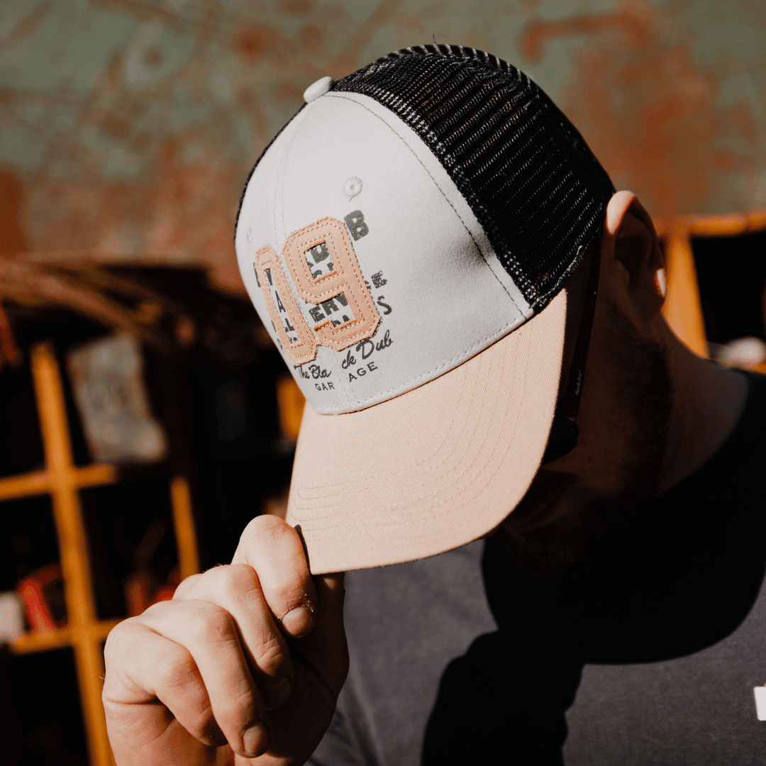 Uggly and Co '09' trucker hat with mesh back and bold logo, designed for casual style and sun protection.