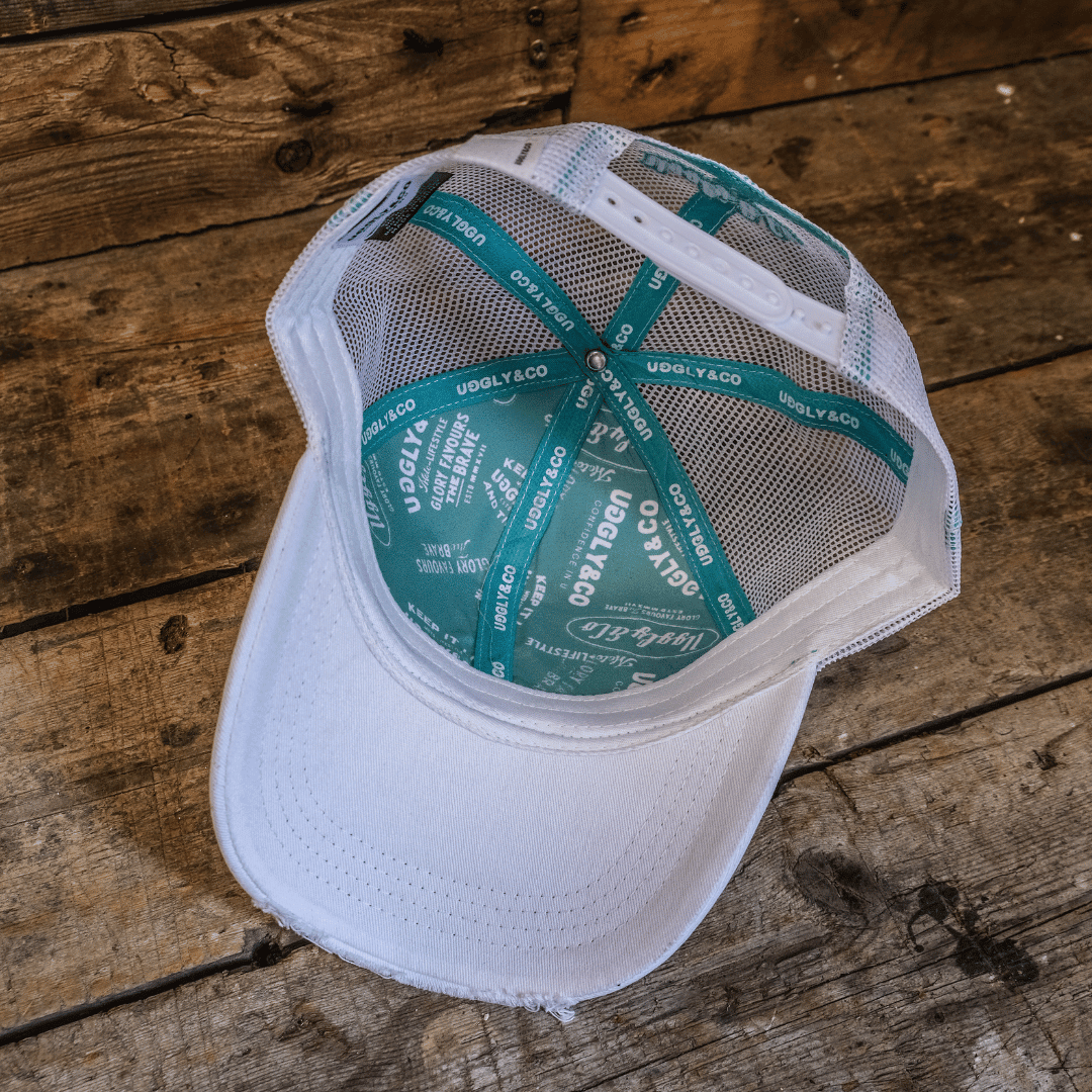 Turquoise and white diamond trucker cap by Uggly and Co featuring mesh back and adjustable strap, motorcycle style.