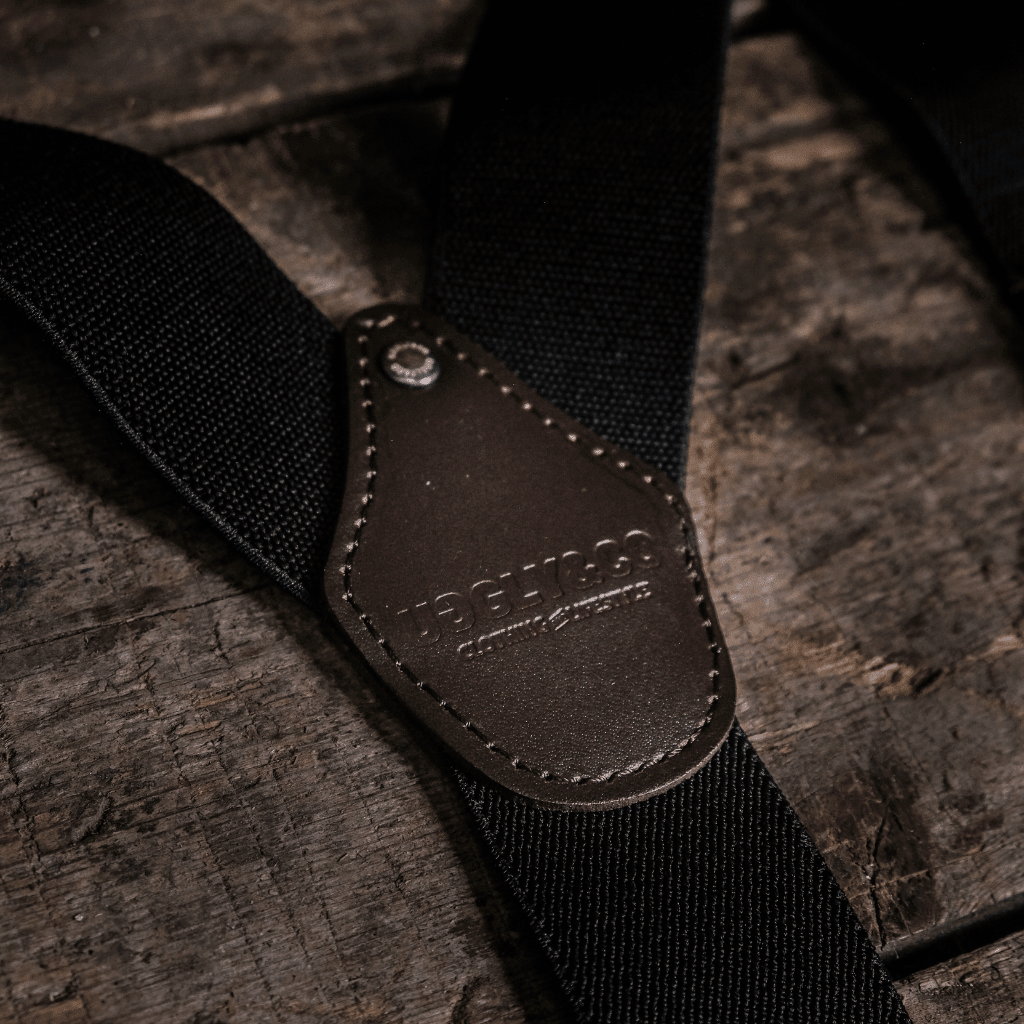 Black utility braces by Uggly and Co, designed as motorcycle riding accessories with adjustable straps and metal hardware.