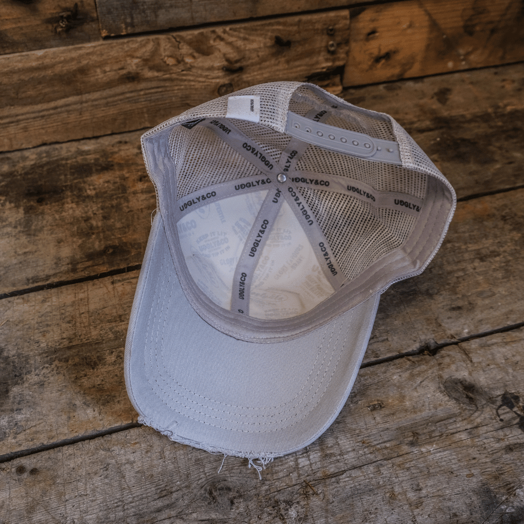 Silver and grey diamond trucker cap by Uggly and Co featuring a motorcycle-inspired design and classic trucker hat style.