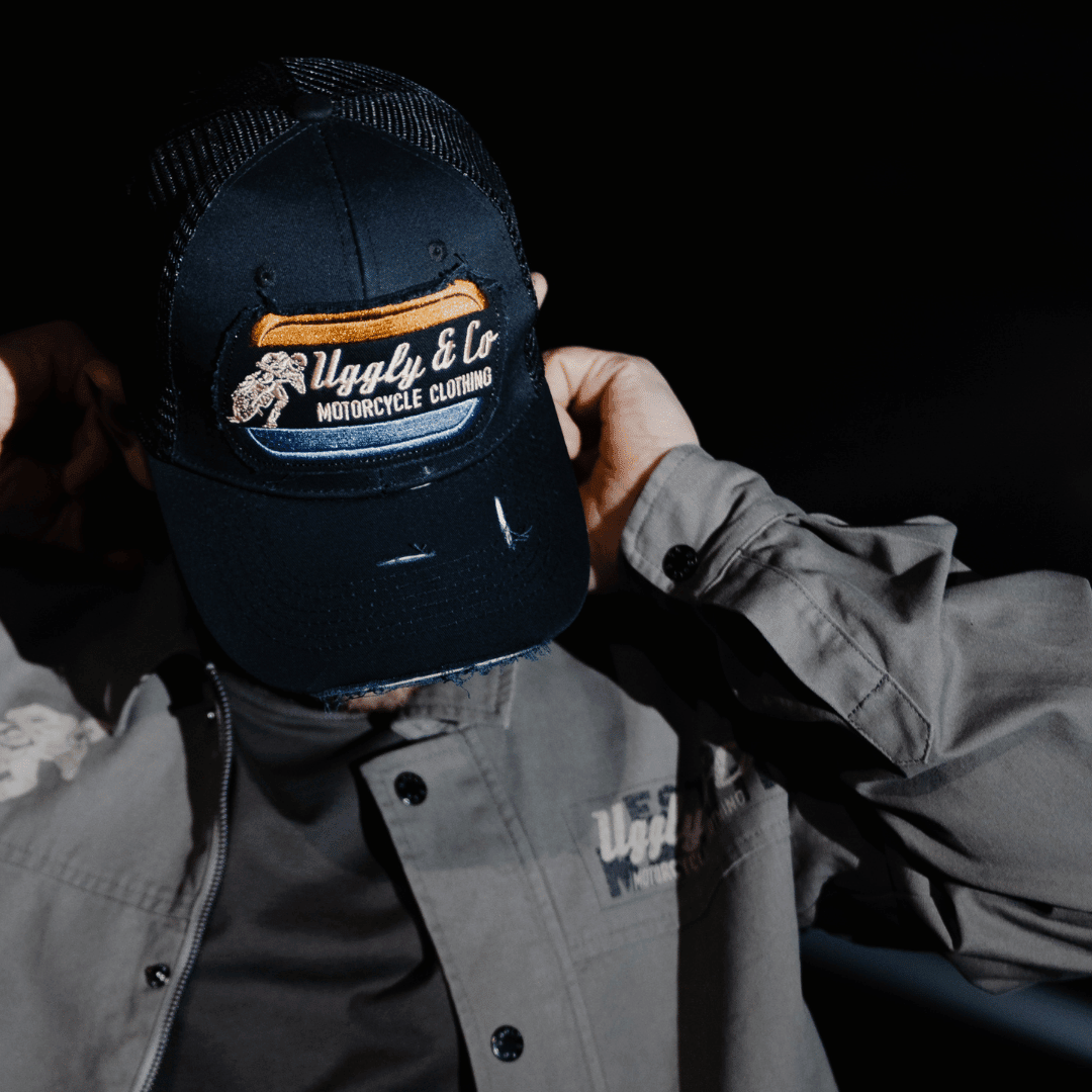 Black flat track trucker hat by Uggly and Co featuring a classic trucker cap design with mesh back and flat brim.