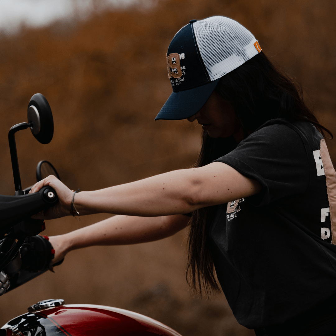 Navy trucker cap with "09" emblem, Uggly and Co brand, featuring mesh back and curved brim for casual style.