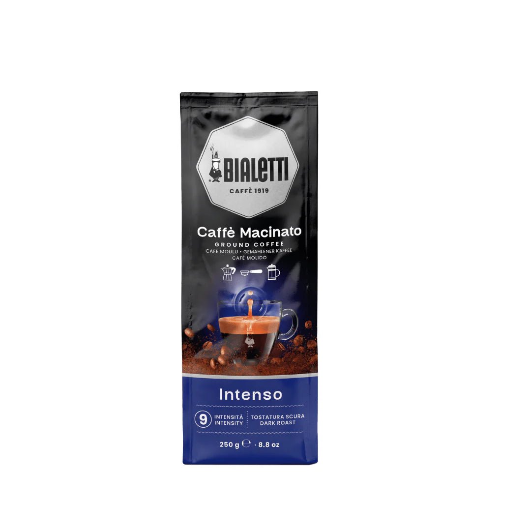 Bialetti Brew Italia Omni Ground Coffee Intenso in a bag with a dark roast label and coffee beans in the background.