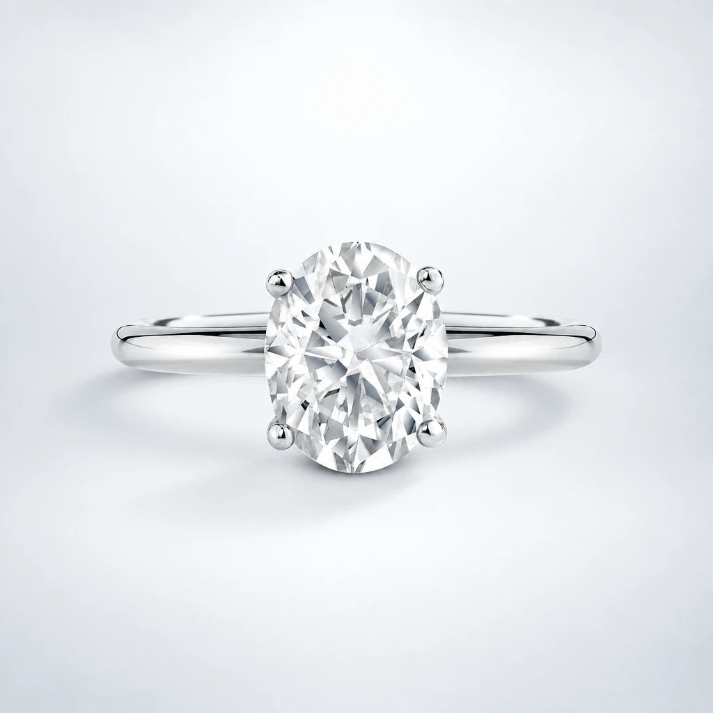 Oval moissanite engagement ring in sterling silver with a solitaire design, displayed on a neutral studio backdrop.