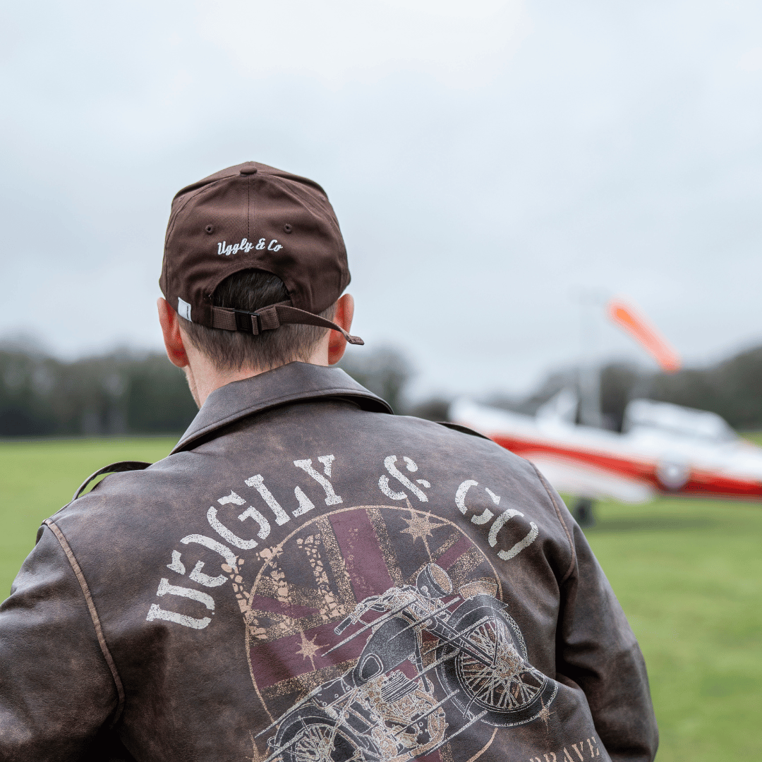 Brown Uggly and Co Aviation Diamond Trucker Cap featuring airplane embroidery on a classic baseball hat style.
