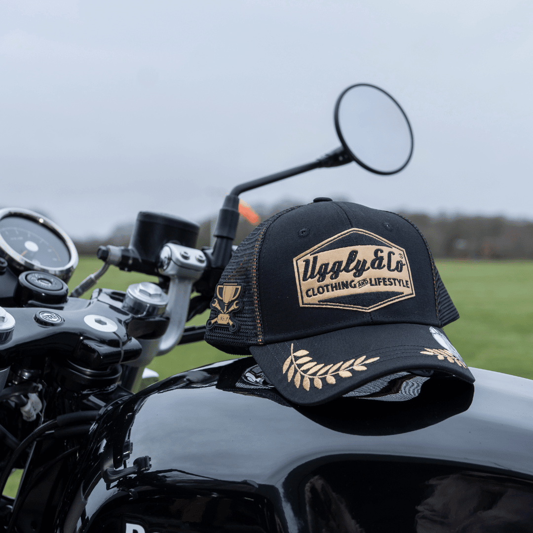 Black and gold Uggly and Co 'Podium' diamond trucker cap with mesh back and curved brim, stylish and comfortable headwear.