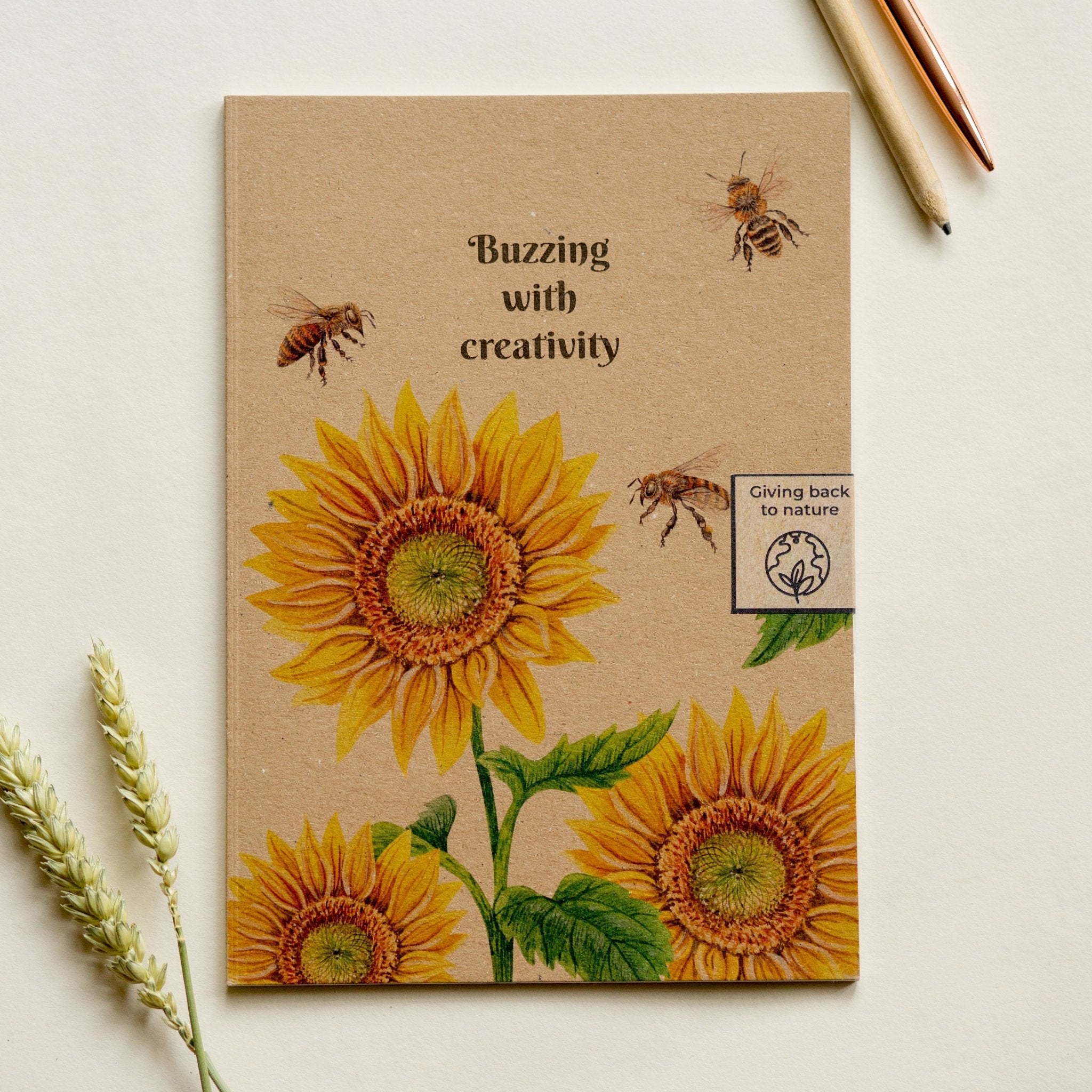 Trouvaille recycled paper notebook with illustrated sunflower and bee cover, featuring a creative, eco-friendly design.