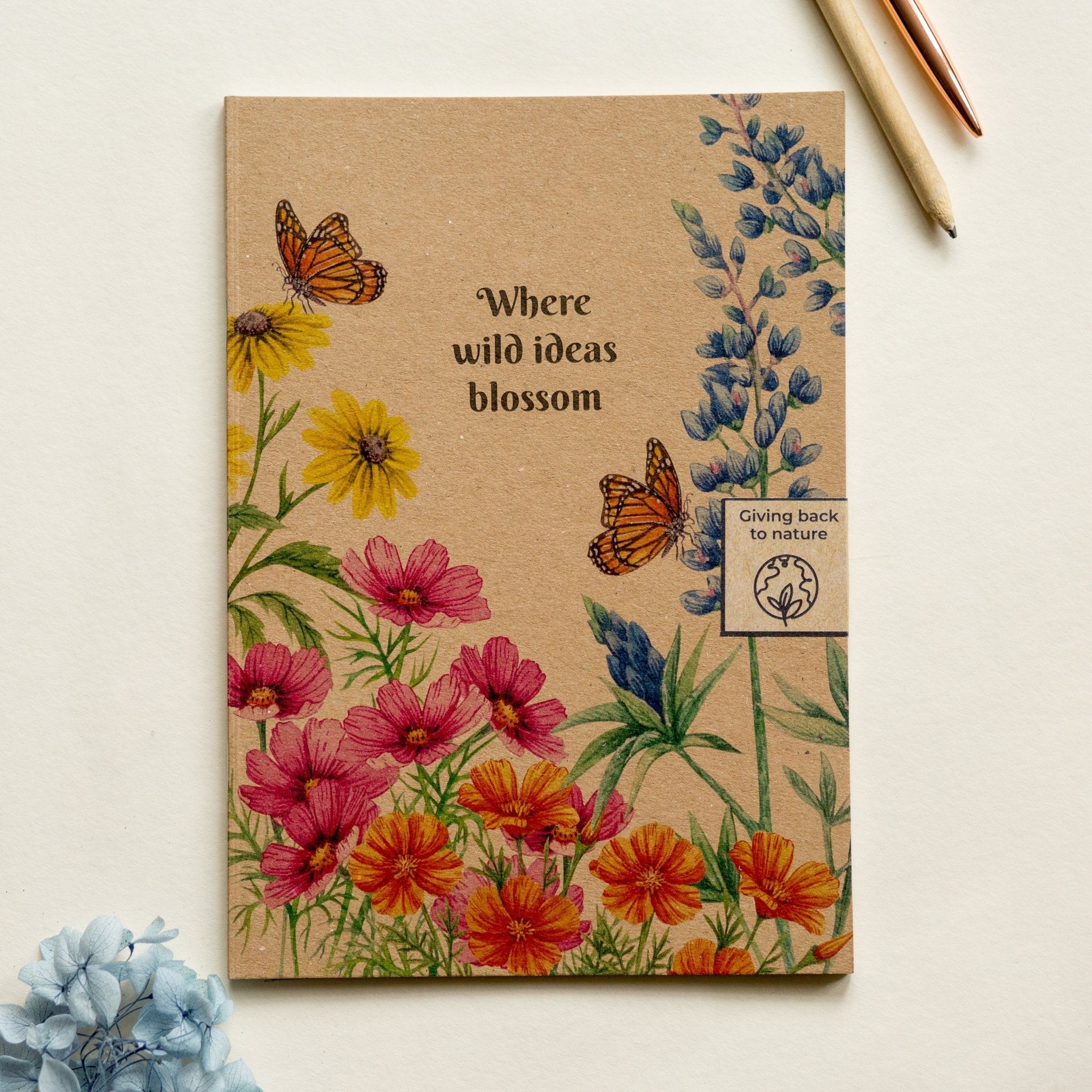 Trouvaille recycled paper notebook with illustrated wildflowers and butterflies on the cover, perfect for creative note-taking.