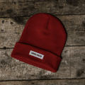 Red Uggly and Co beanie hat with a cozy knit design, perfect for warmth and casual style.