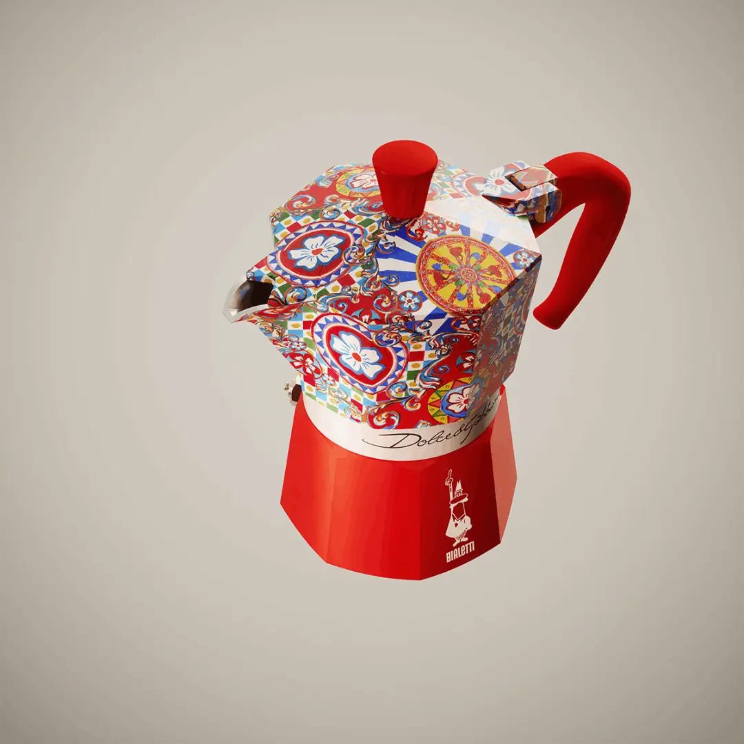 Red Bialetti Moka Express coffee maker with Dolce & Gabbana Sicilian Cart design, Brew Italia brand, stovetop espresso pot.