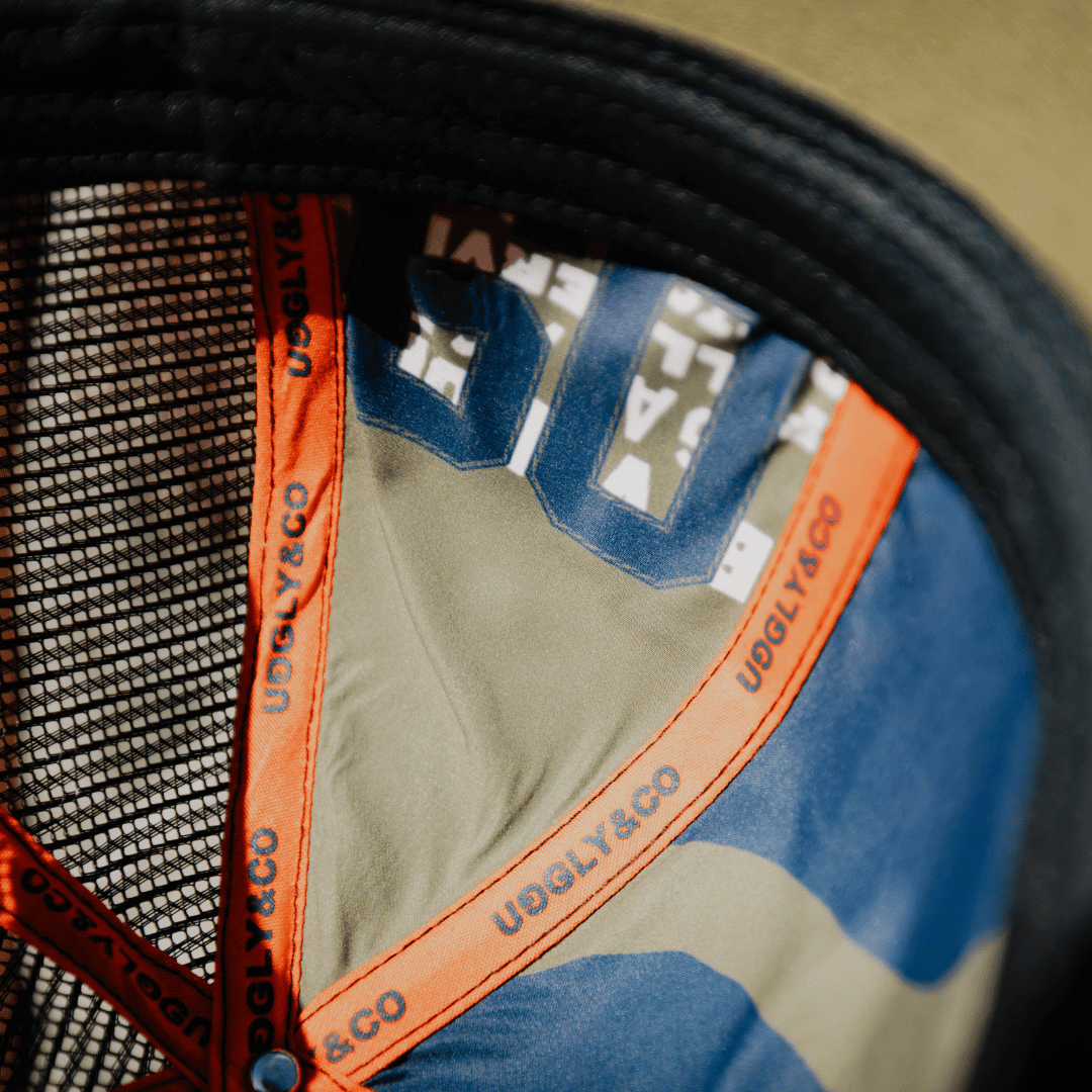 Green Uggly and Co '09' trucker cap with retro biker hat design, featuring mesh back and adjustable snap closure.