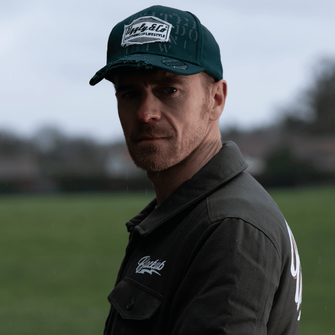 Green Uggly and Co Aviation Diamond Trucker Hat, retro-style baseball cap with flat track design and embroidered aviation motif.