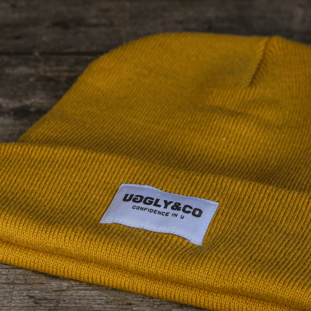Yellow Uggly and Co beanie with a cozy knit design, perfect for casual winter wear.