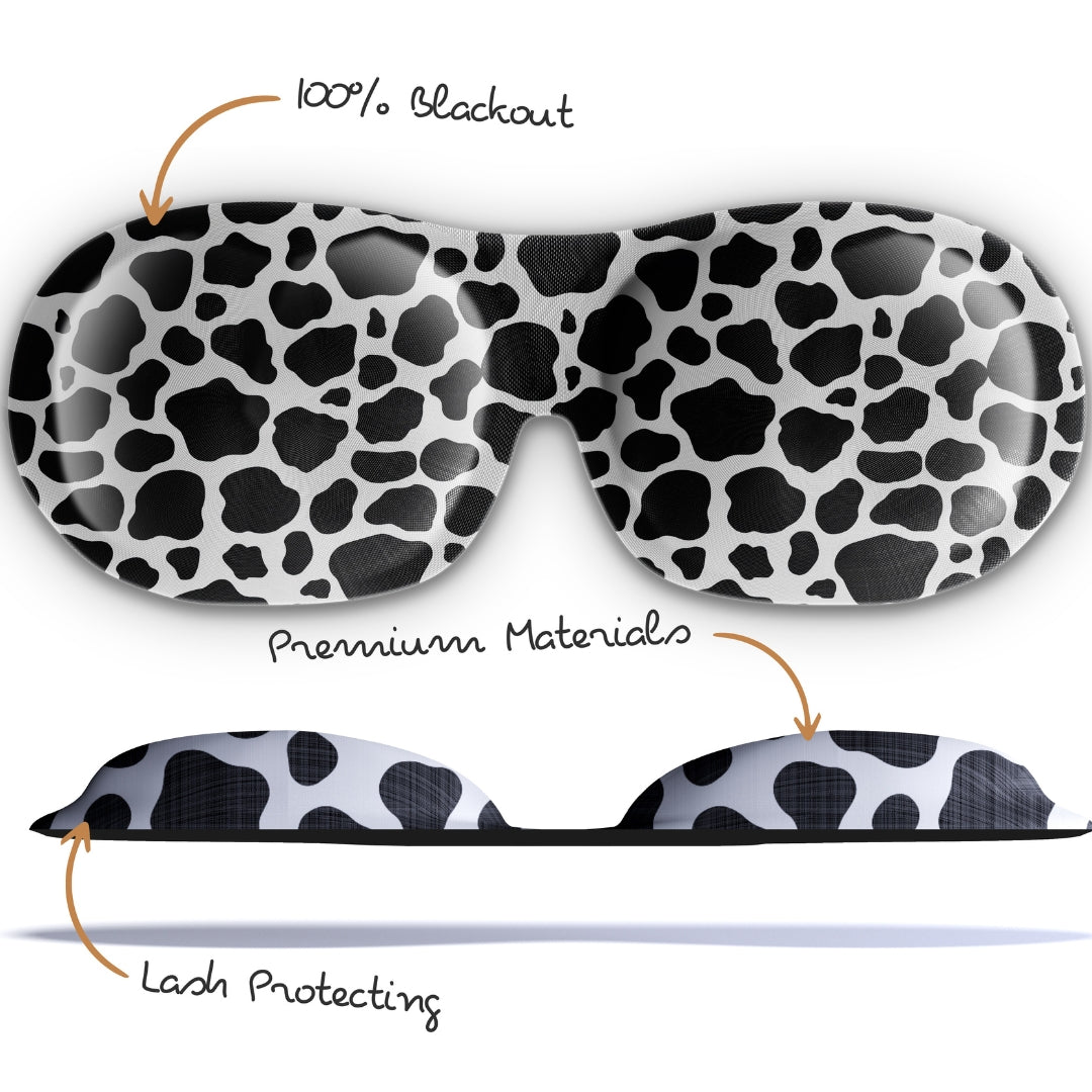 Contoured SMUG sleep mask with black and white cow print, designed for blackout and comfortable sleep.