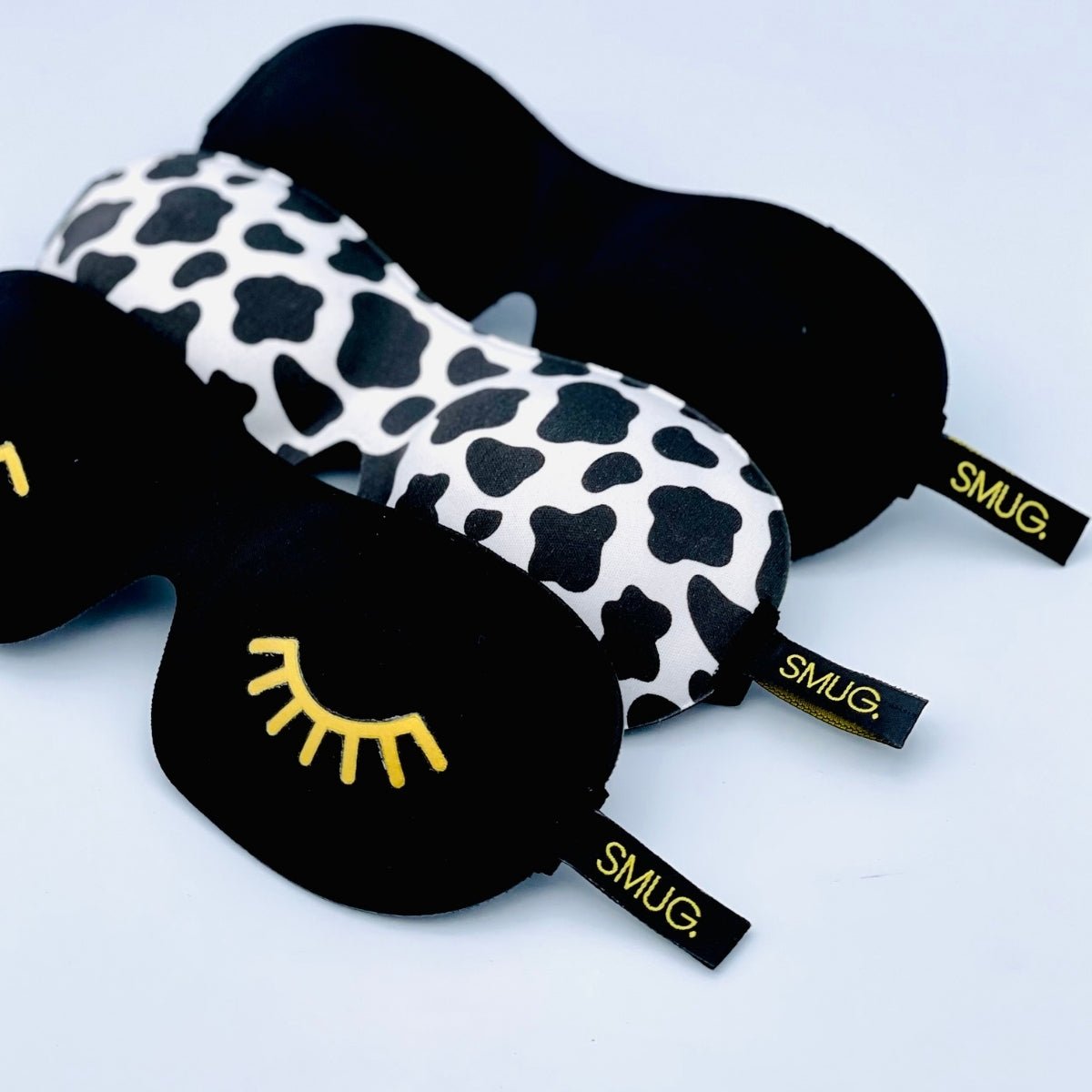 Contoured SMUG 3D blackout sleep mask with black cow print, designed for comfortable light blocking and sleep enhancement.