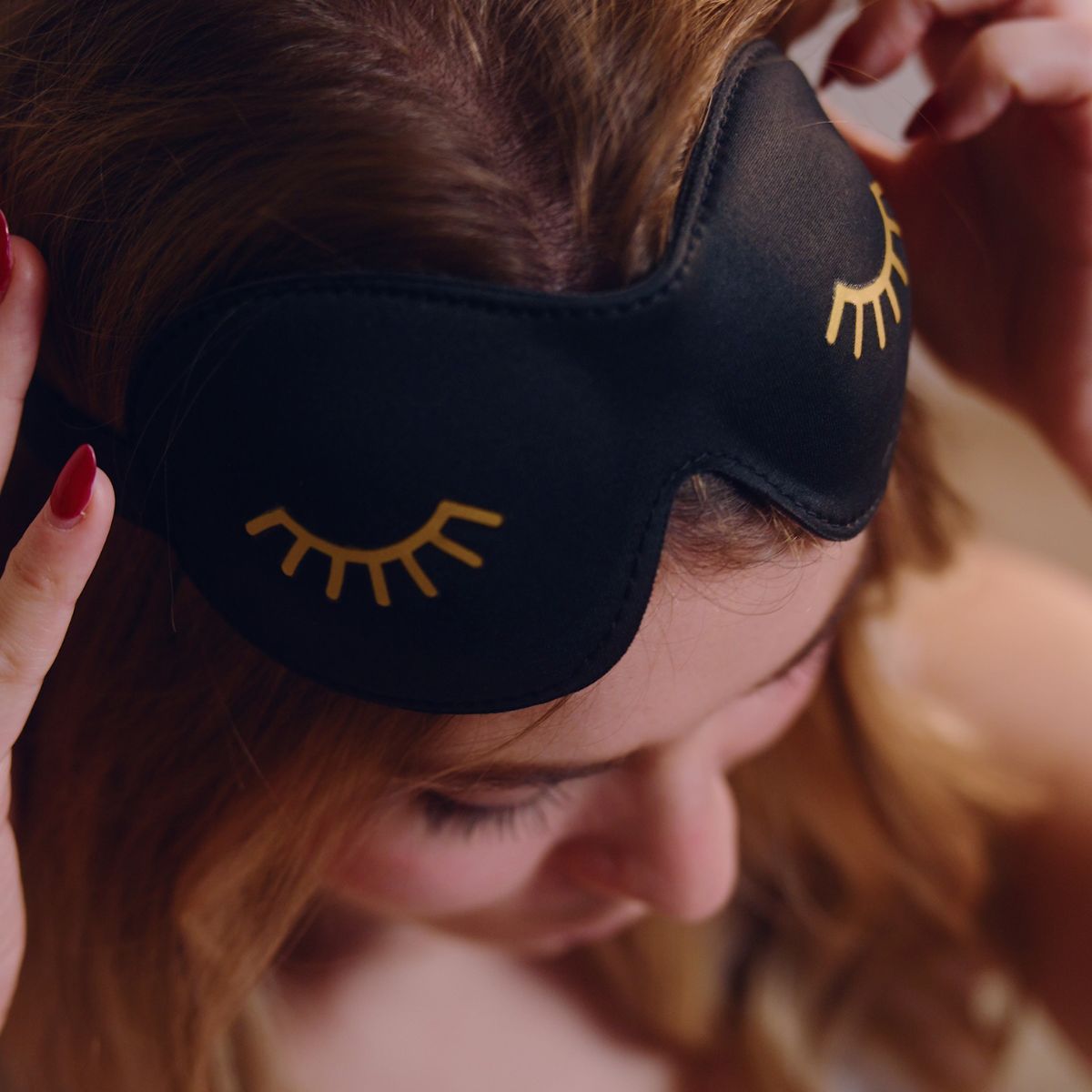 Close-up of SMUG contoured sleep mask set in black with wink design, showcasing the soft fabric and ergonomic shape for comfortable sleep.