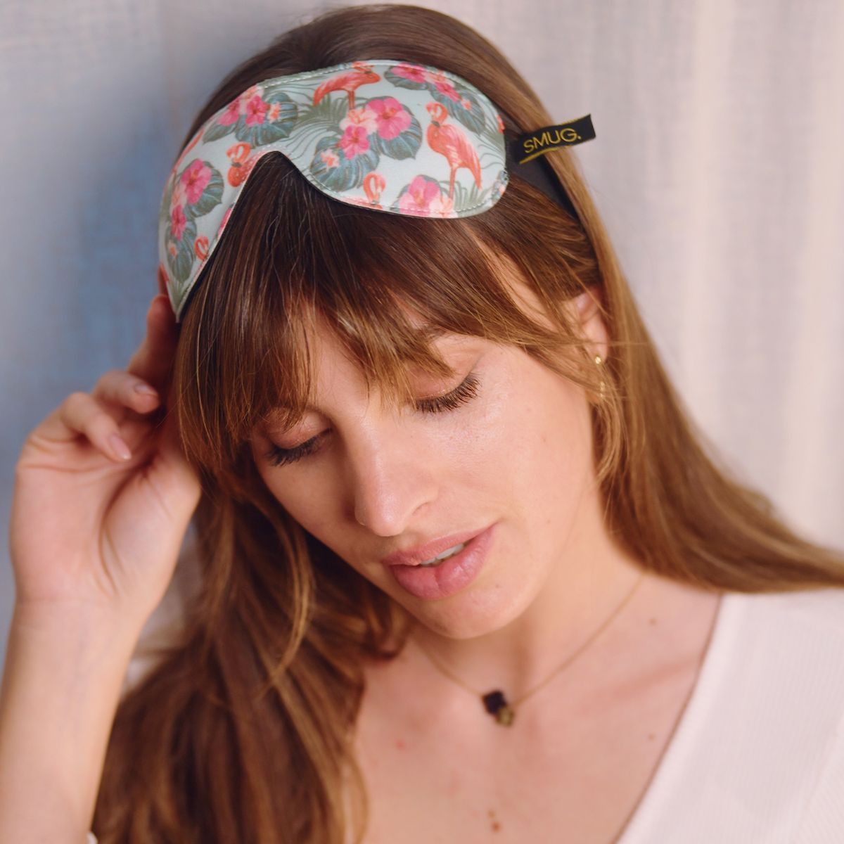 Contoured black sleep mask with flamingo print by SMUG, designed to block out light for restful sleep.