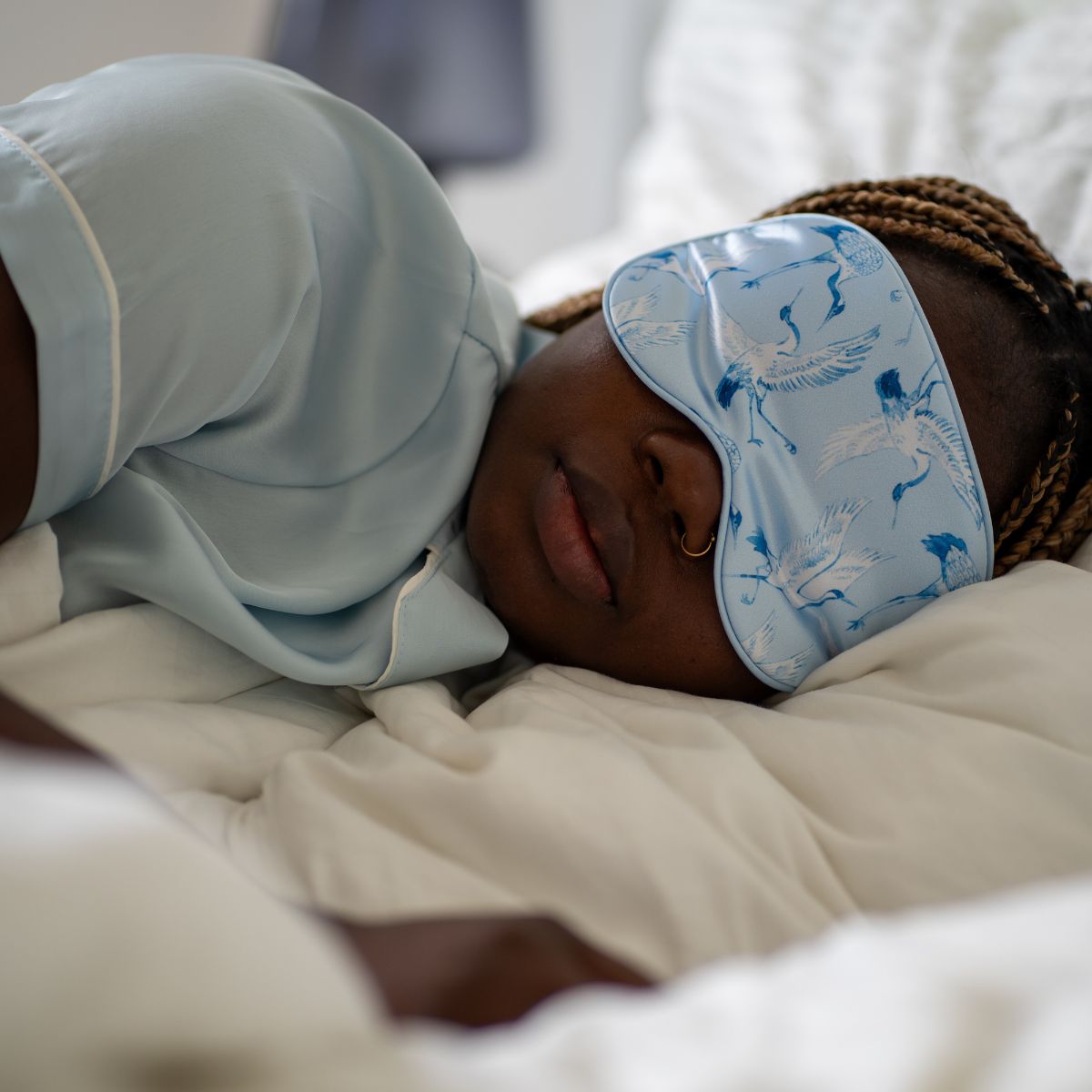 Soft satin sleep mask with elegant cranes print by SMUG, designed for comfortable sleep and relaxation.