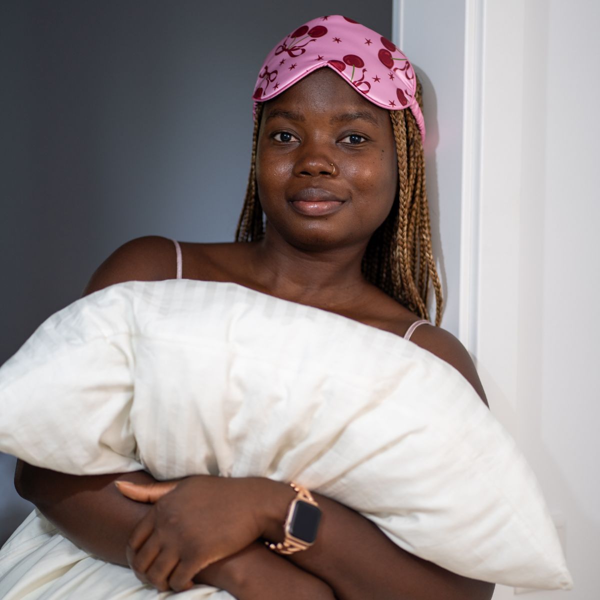 Pink satin sleep mask with cherry print by SMUG, featuring a smooth, luxurious fabric design for restful sleep.