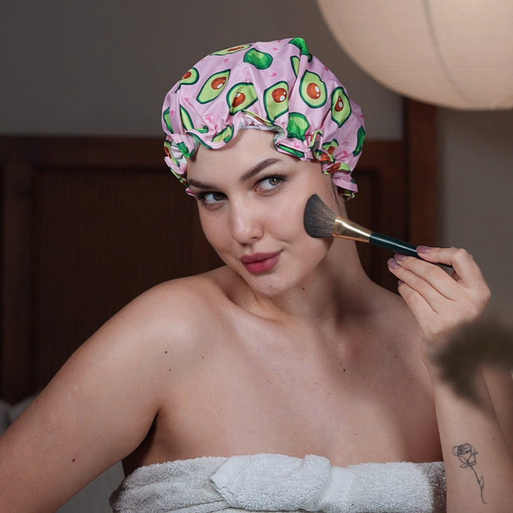 SMUG avocado print shower cap with waterproof material, shown next to a towel and makeup brushes.